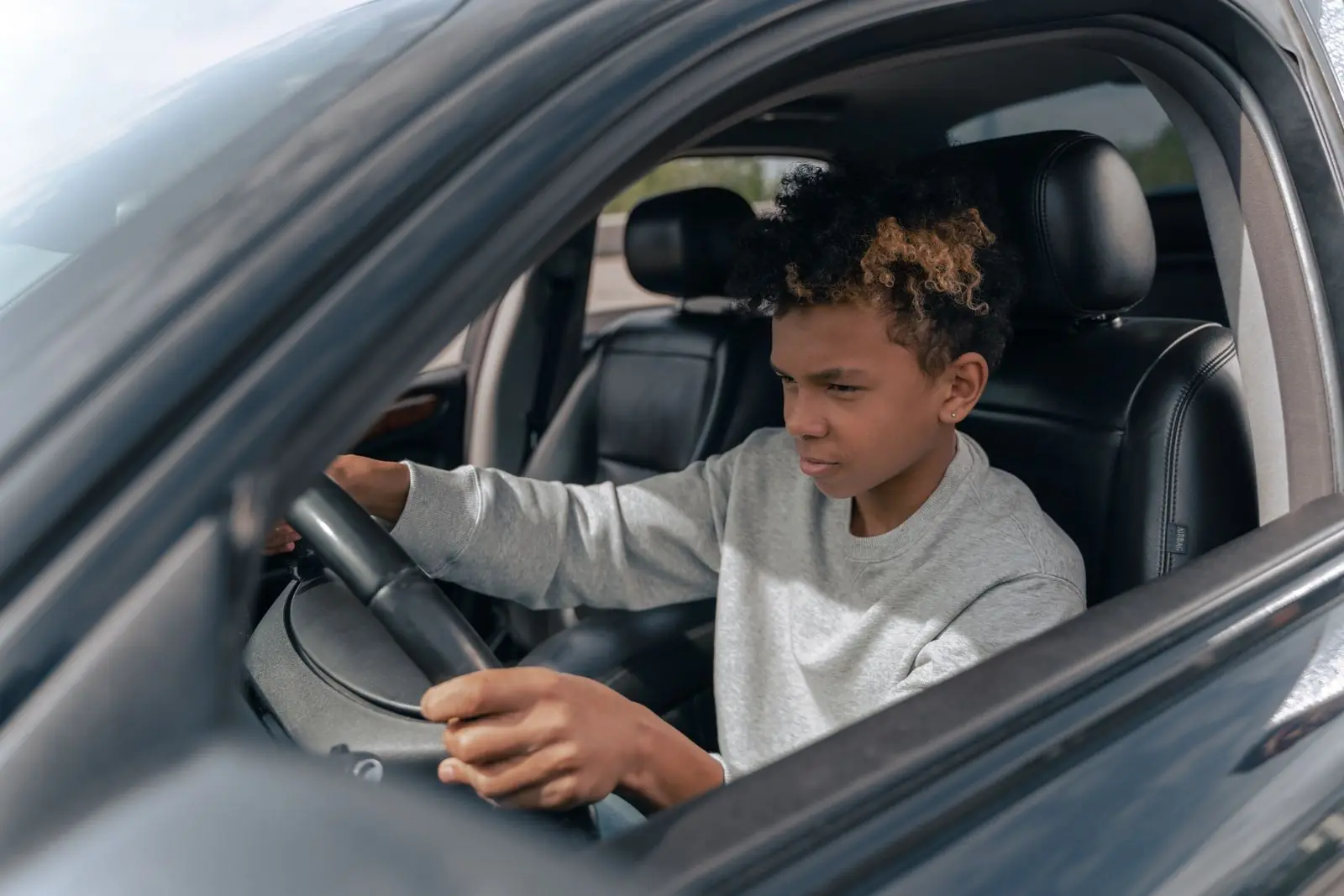 A teenage learner concentrating during an in-car driving lesson