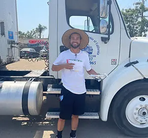 A CDL of California student standing beside the school’s training tractor