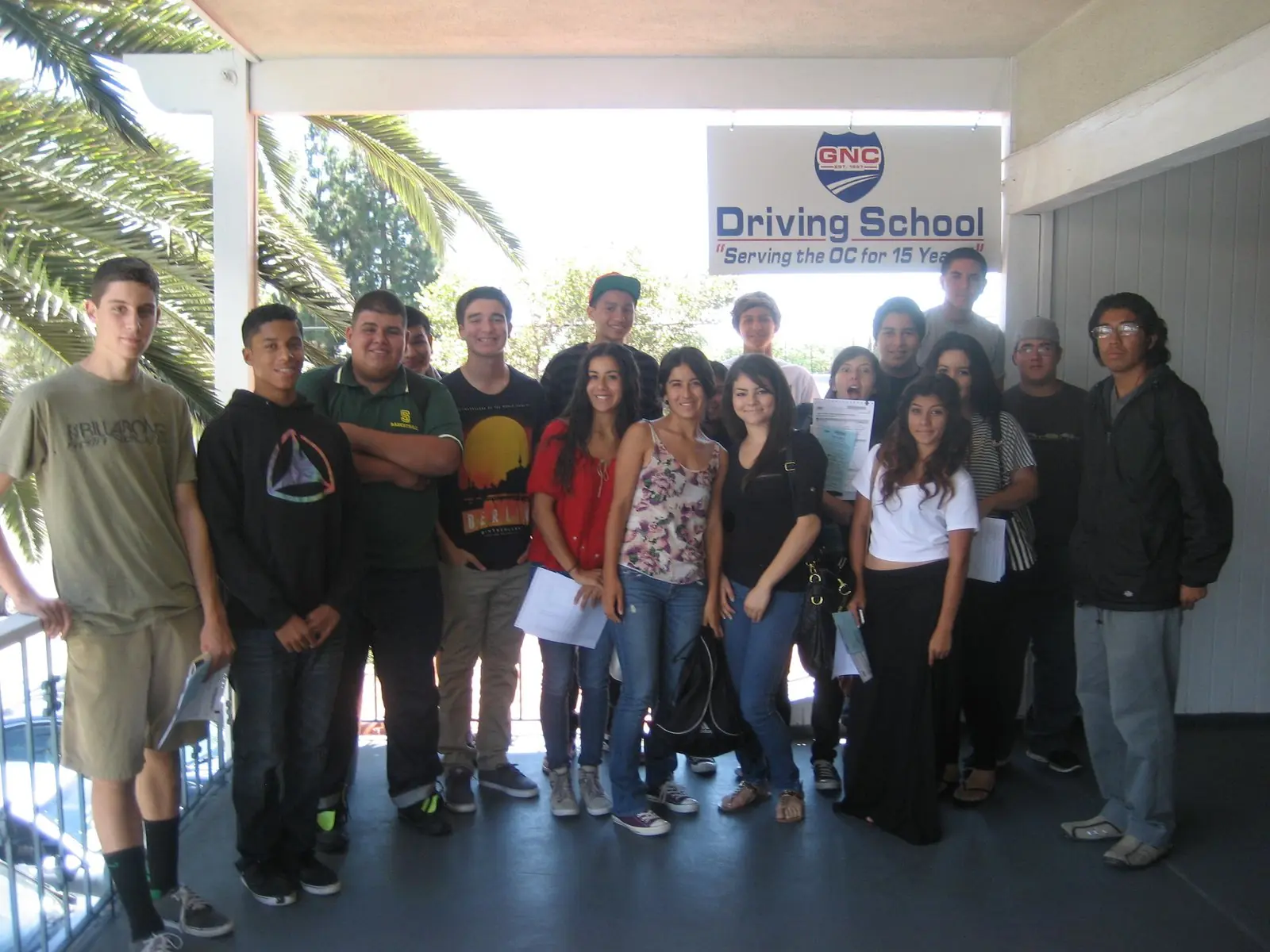 A GNC Driving School class outside the school’s office in Orange, under the GNC sign