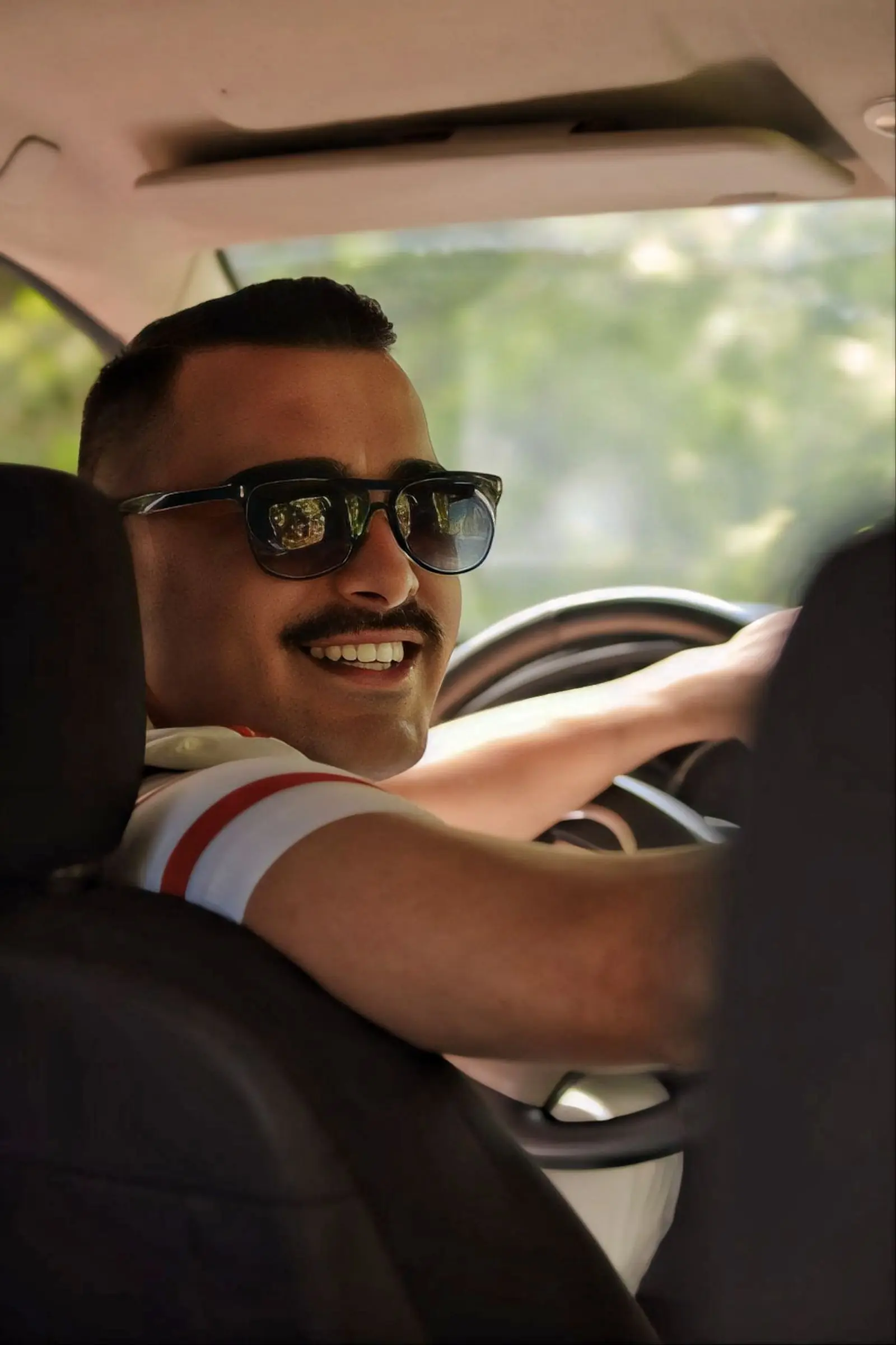 A confident adult driver smiling behind the wheel