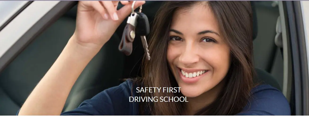 A smiling young driver in the driver’s seat holding up a set of car keys