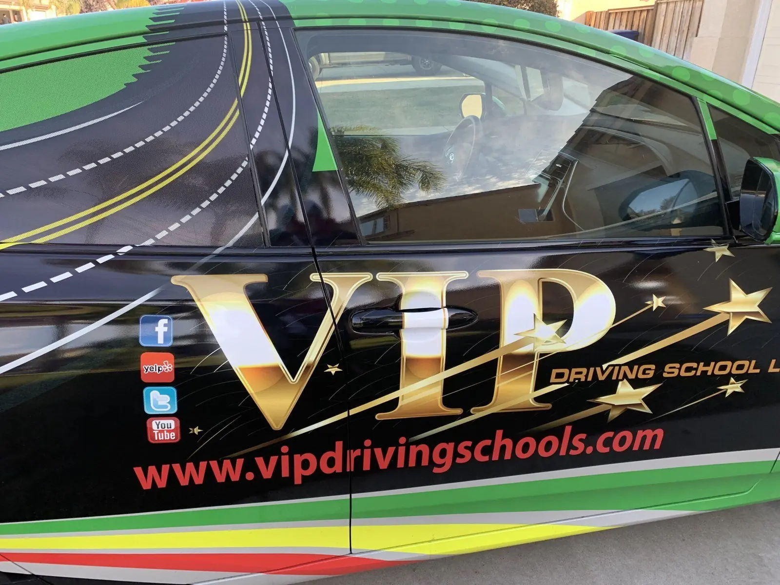 A VIP Driving School training car in the school’s green, black and gold wrap