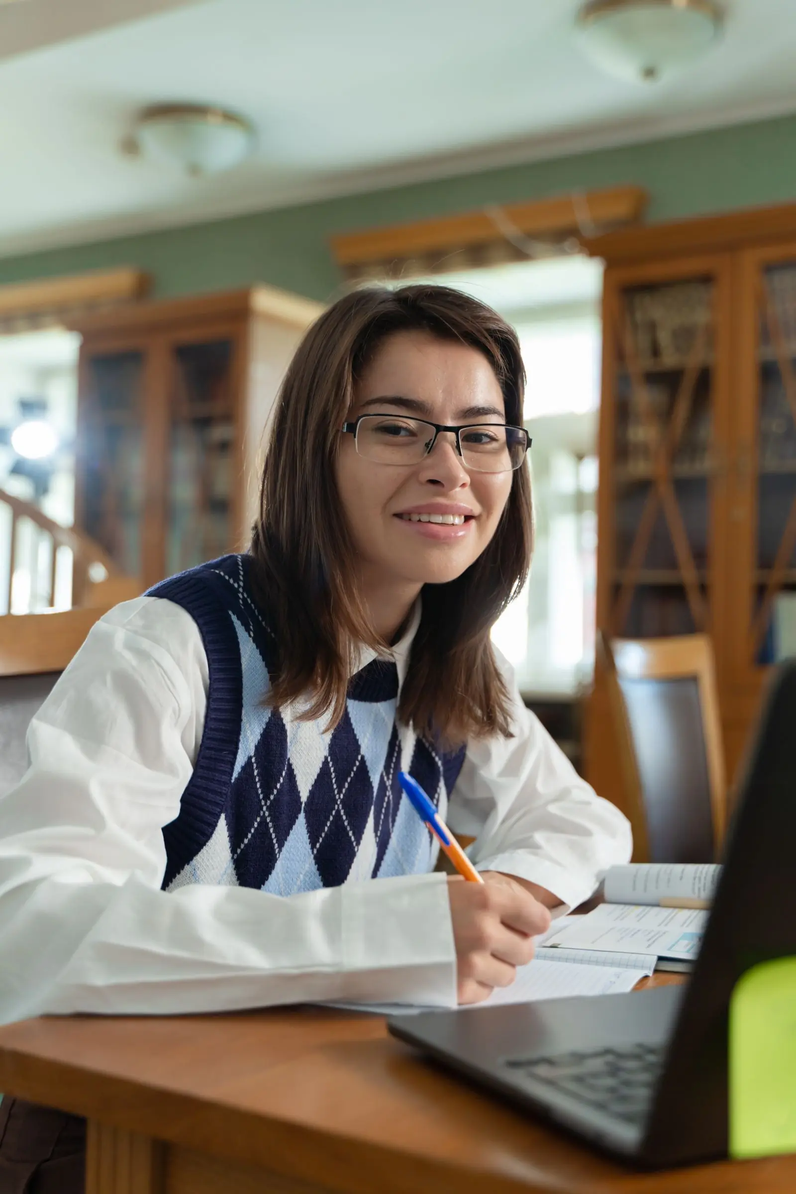 A student smiling while working through driving theory on a laptop